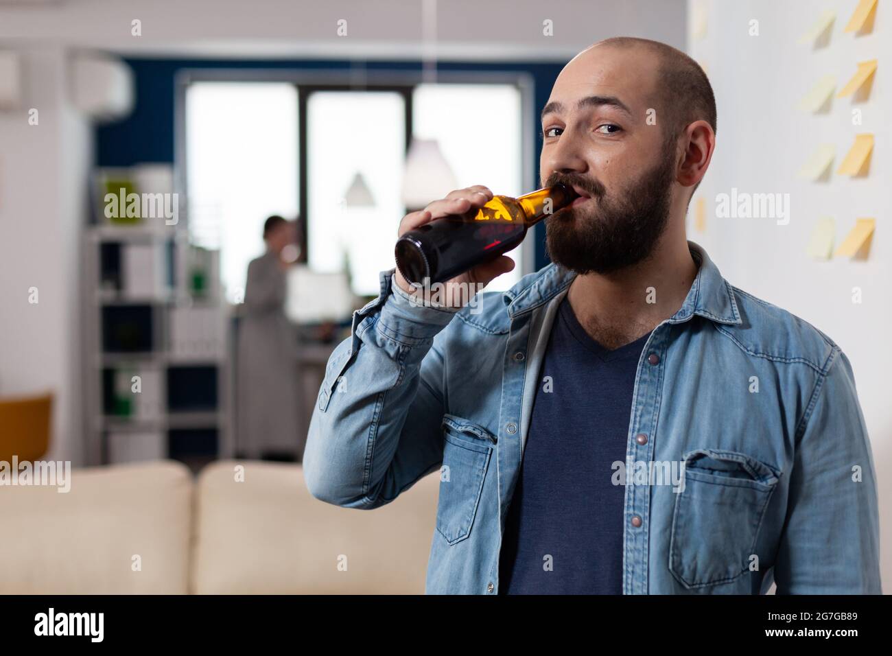 Man drinking bottle of beer after work meeting with colleagues for fun