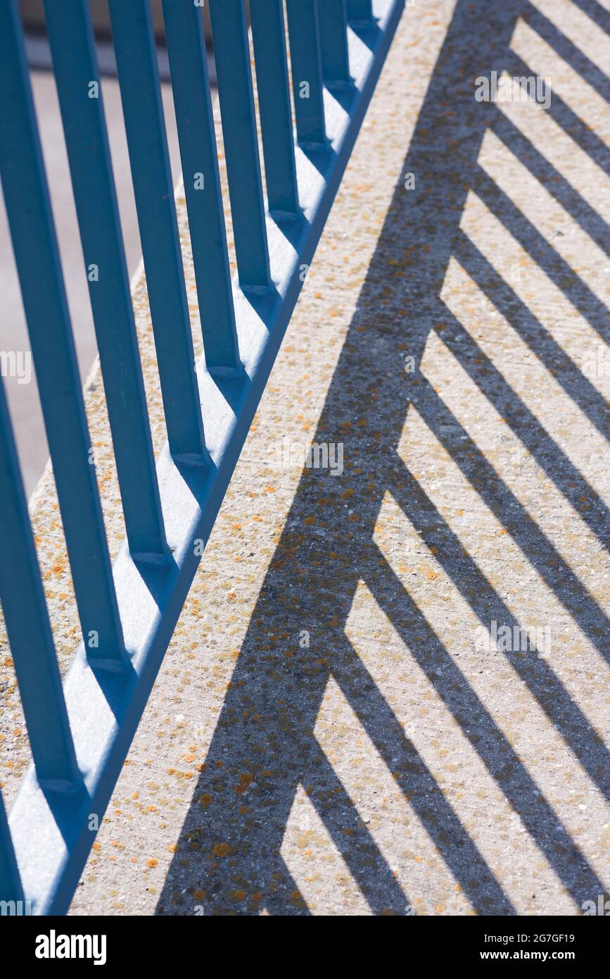 Blue railing, rods with shadow Stock Photo - Alamy
