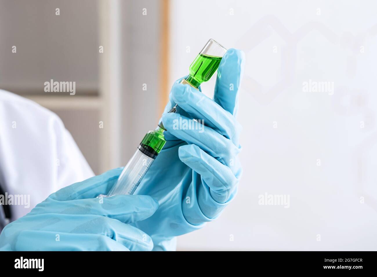 Doctor hand holding syringe and vaccine in blue gloves to prepare prevent pandemic of the disease, flu or influenza virus. Stock Photo