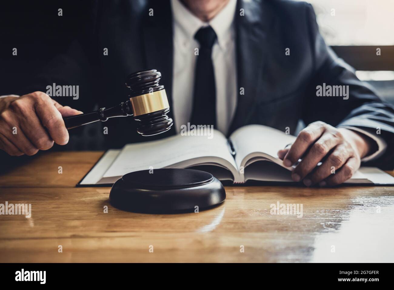 Male lawyer or judge working with contract papers, Law books and wooden