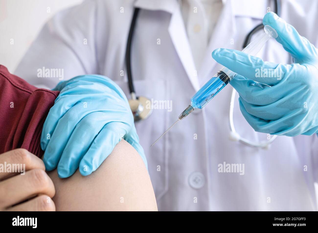 Doctor making injection vaccination patient to prevent pandemic of the disease, flu or influenza virus in clinic. Stock Photo