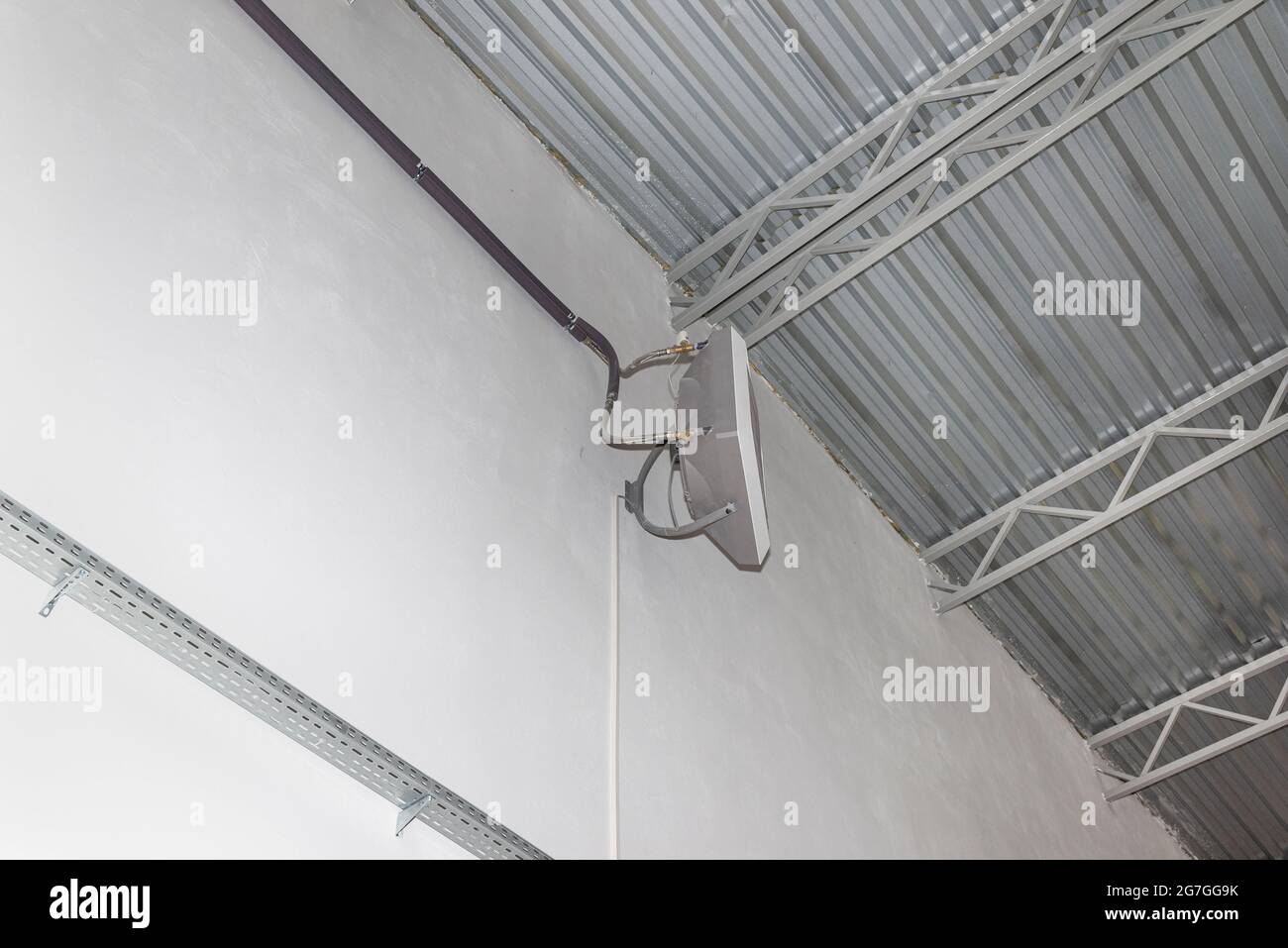 Industrial heater, hanging on the wall of the hall, used for air heating and for cooling with cold water. Stock Photo