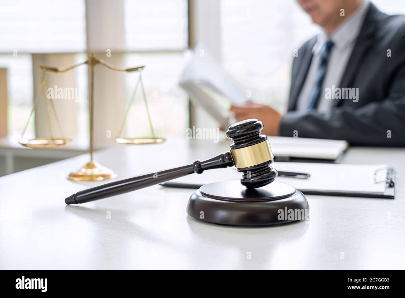 Judge gavel with Justice lawyers, Counselor in suit or lawyer working on a documents in courtroom, Legal law, advice and justice concept. Stock Photo