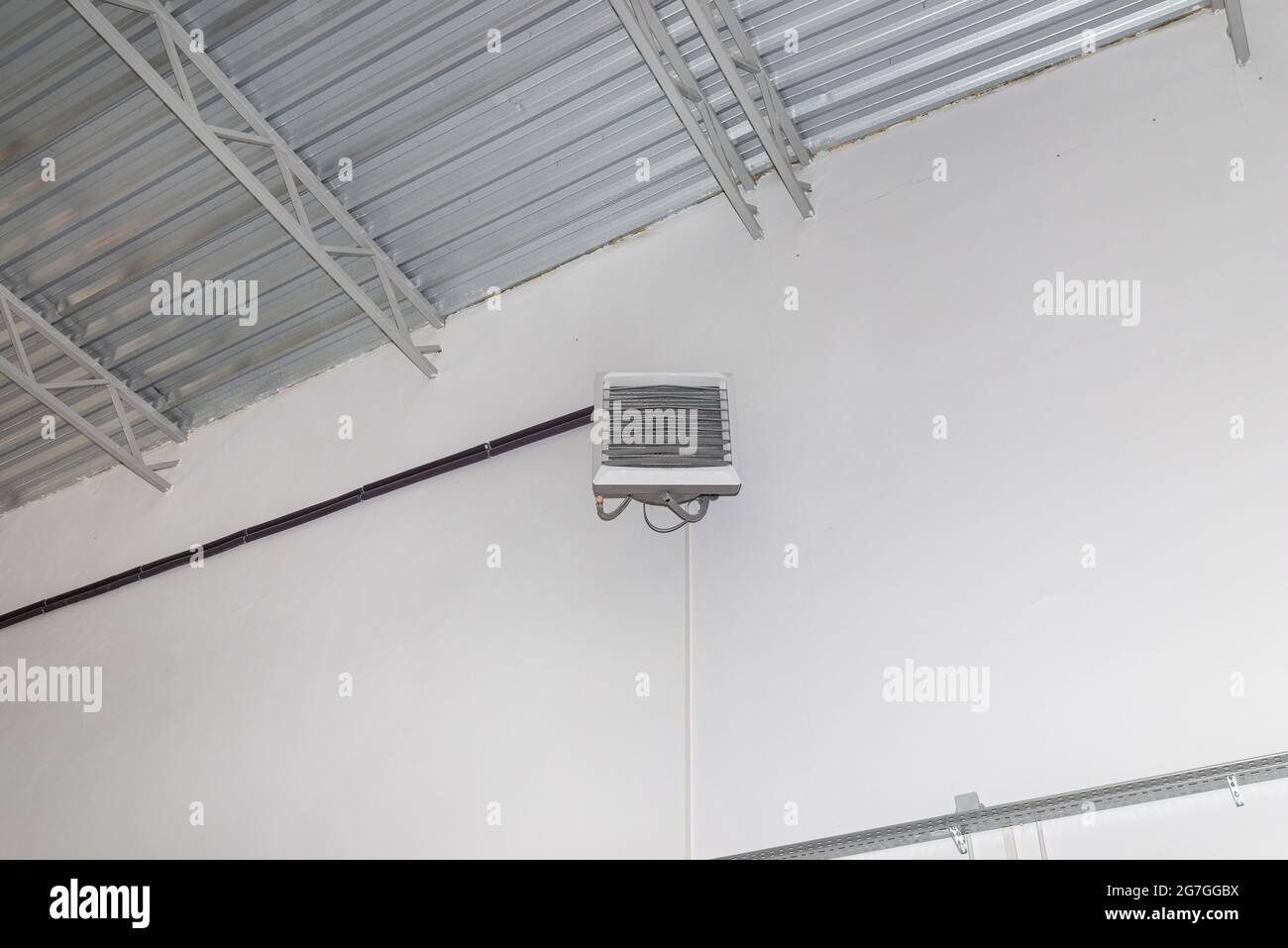 Industrial heater, hanging on the wall of the hall, used for air heating and for cooling with cold water. Stock Photo