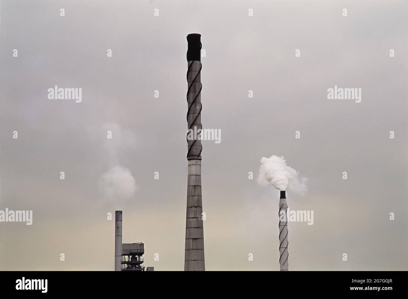 Three factory smokestacks. Stock Photo