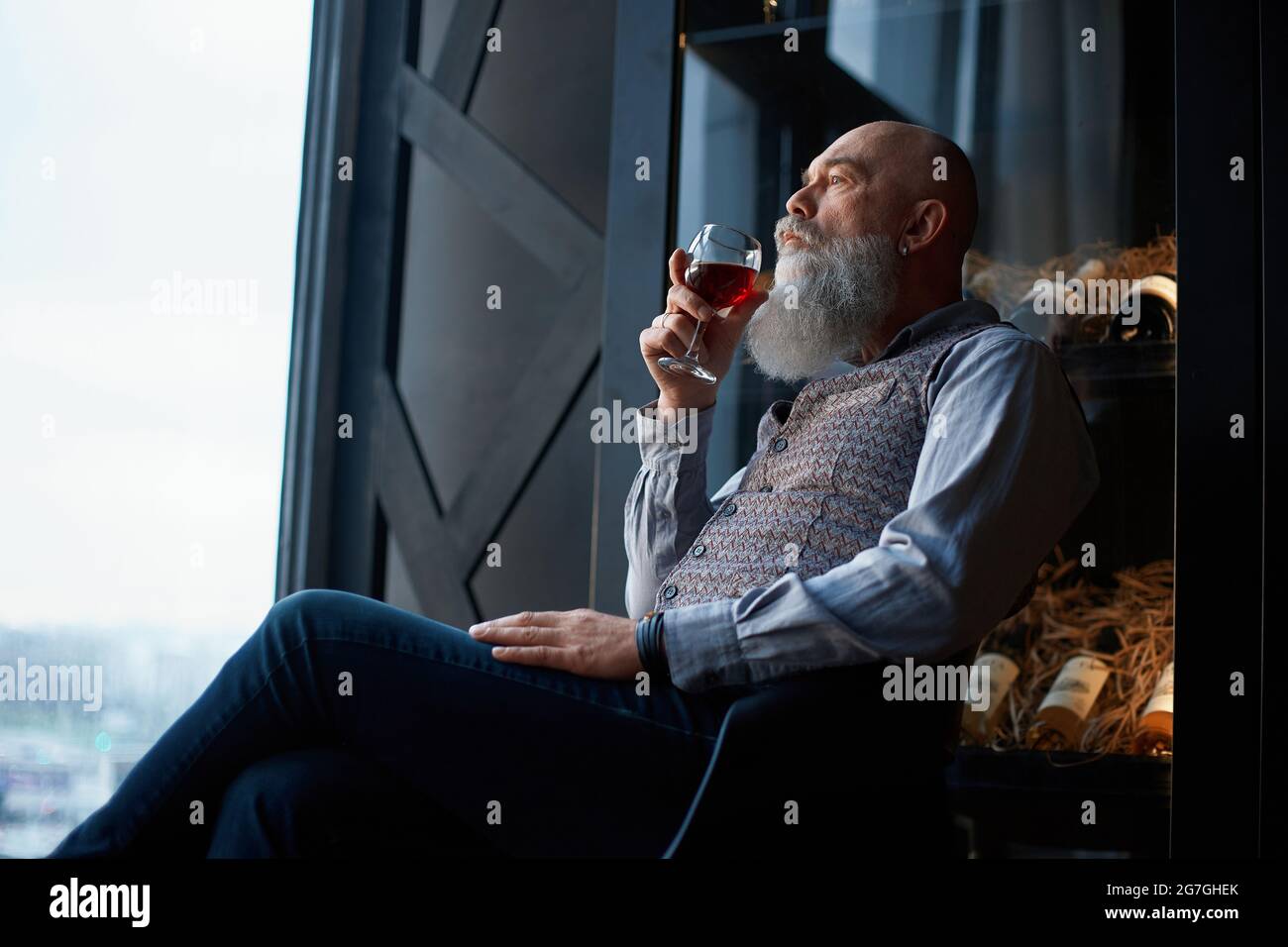 handsome man tasting red wine sitting in the wine room Stock Photo - Alamy