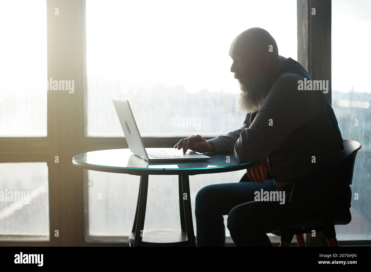 business man using laptop sitting near panoramic window . Stock Photo