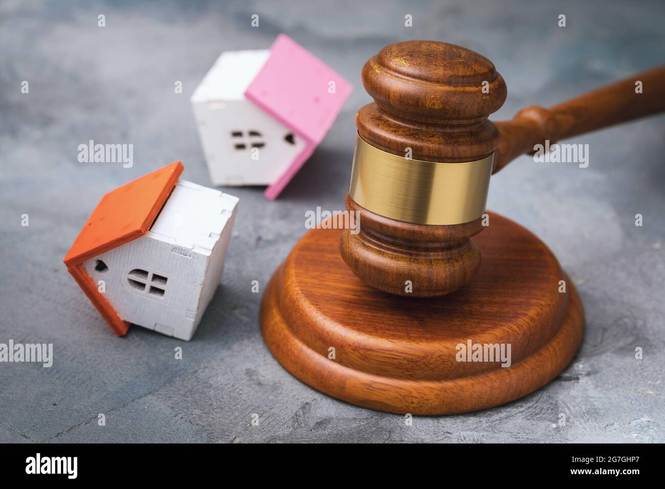 Auction hammer and overturned toy houses on the table, real estate sale concept Stock Photo