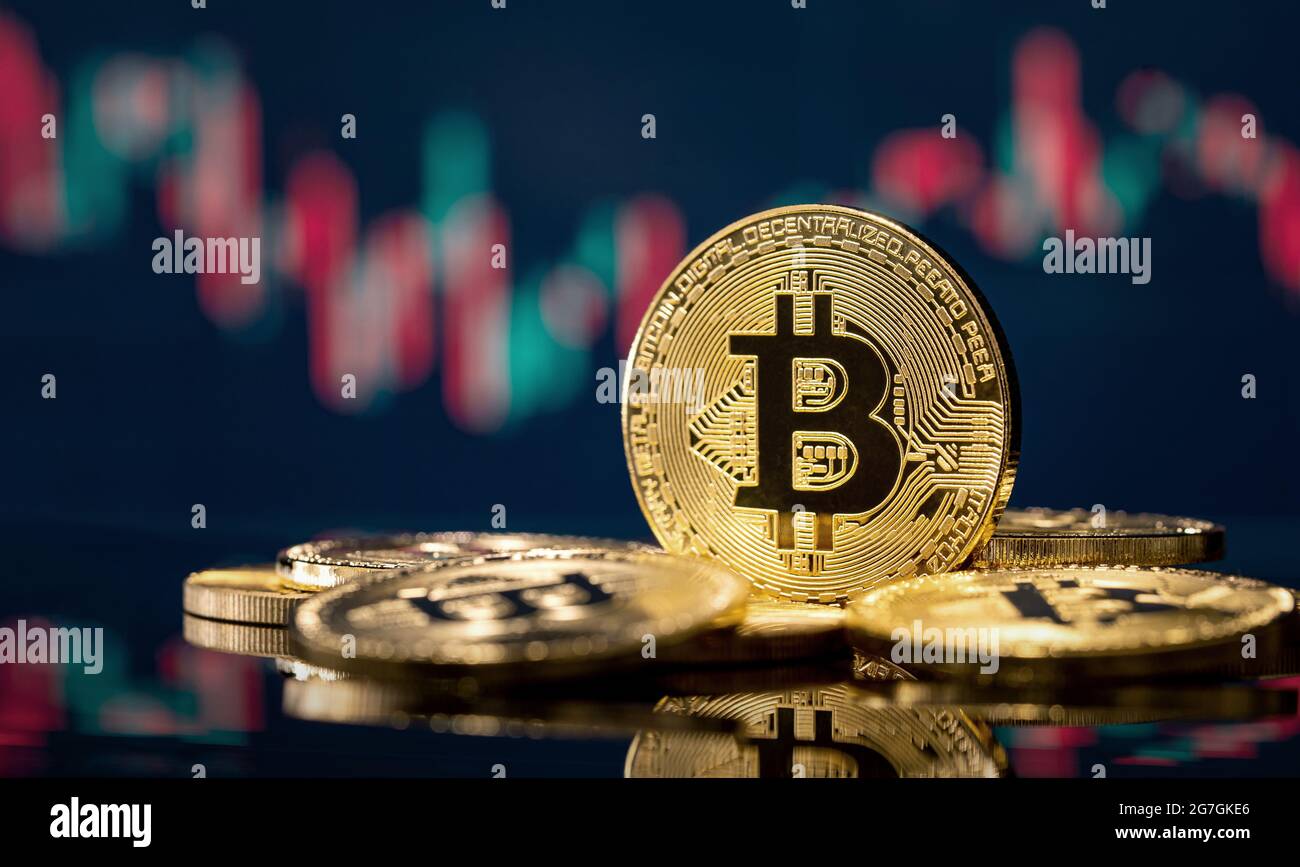 Golden bitcoin coin over defocused stock chart with copy space Stock Photo