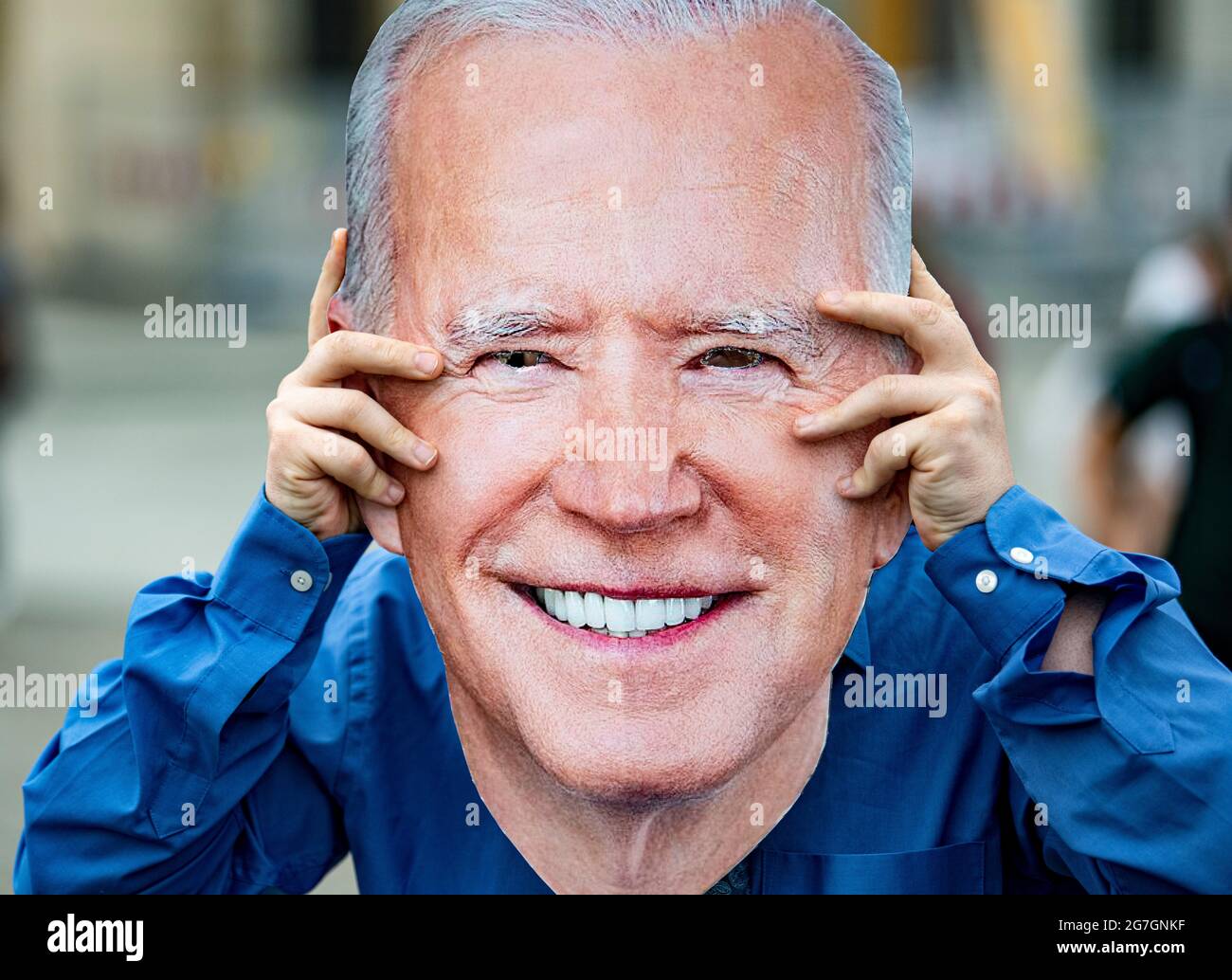 Berlin, Germany. 14th July, 2021. An activist holds a mask of US President Biden in front of his face in front of the Brandenburg Gate. Avaaz activists are calling for the temporary suspension of patent protection for Covid vaccines. Credit: Fabian Sommer/dpa/Alamy Live News Stock Photo