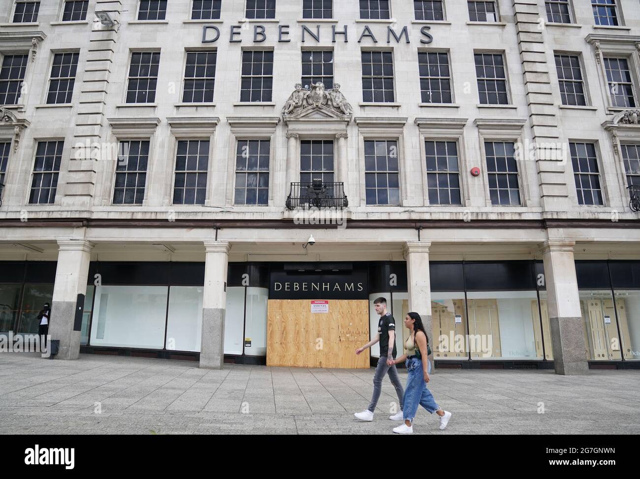 Members of the public walk past a closed Debenhams store in Nottingham, during the easing of lockdown restrictions in England. Picture date: Wednesday July 14, 2021. Stock Photo