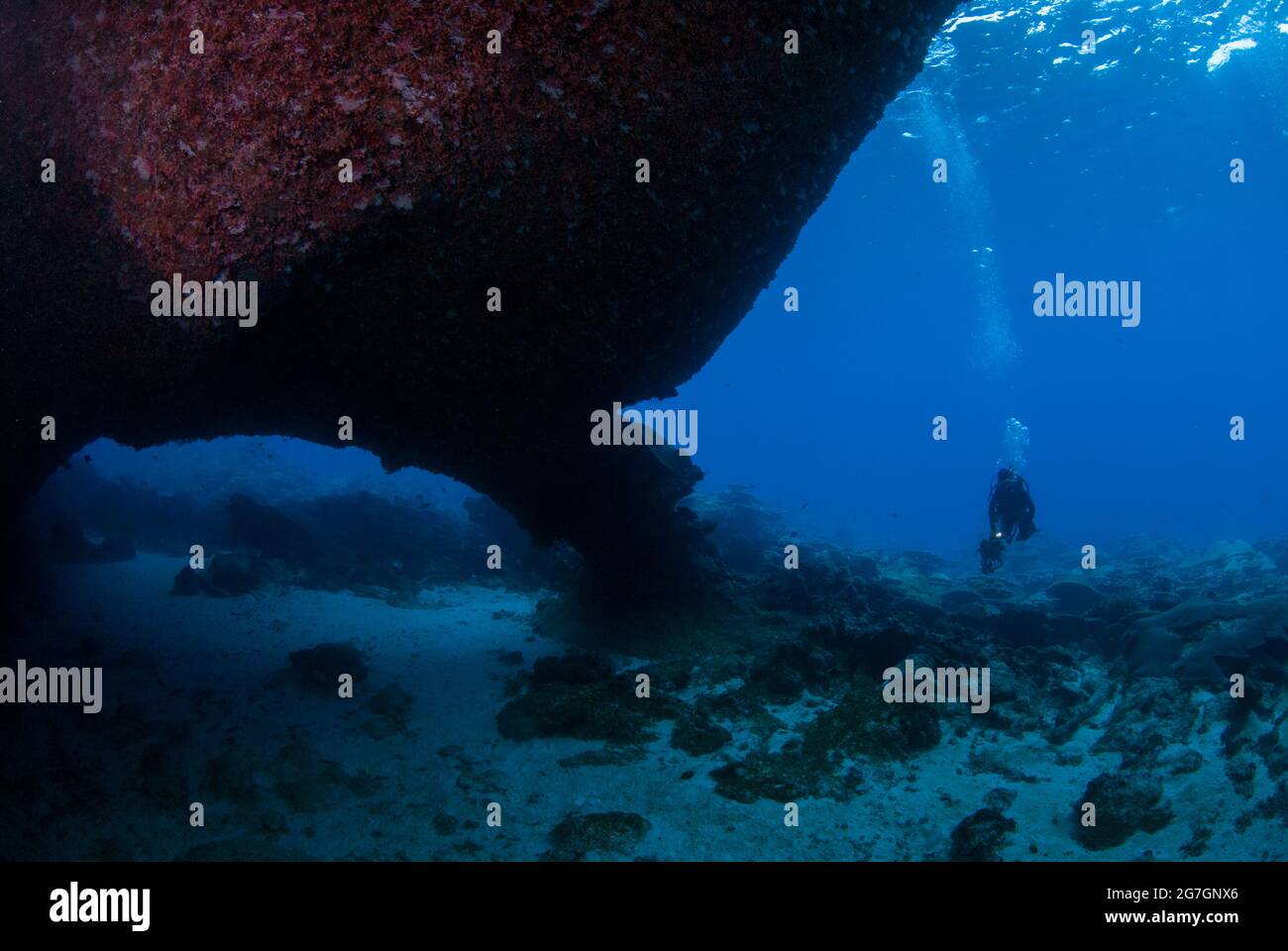 Diver by passageway in cave, West White Beach Cave dive site, Christmas