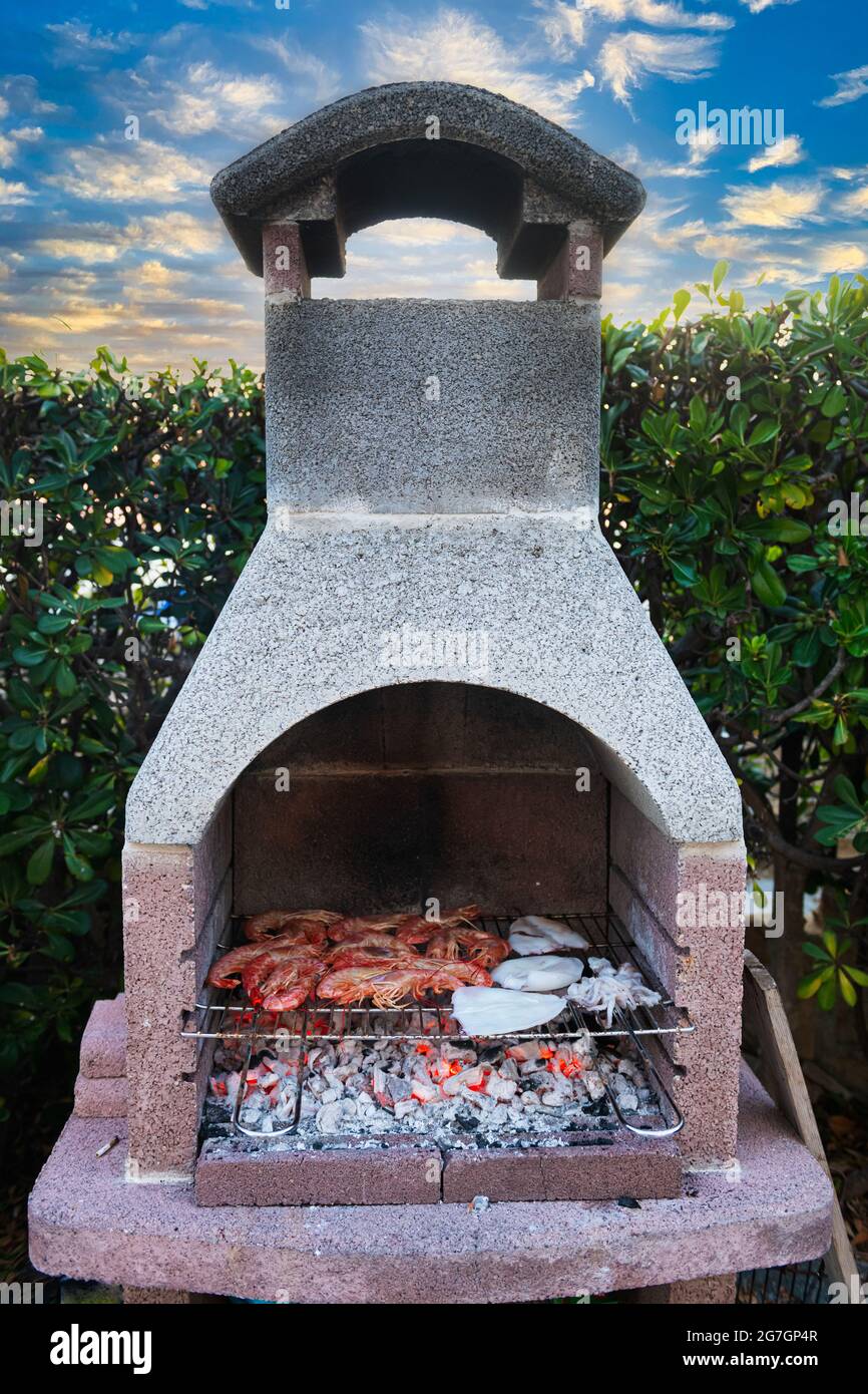 Stone oven outdoors cooking mixed seafood prawns and squid Stock Photo -  Alamy