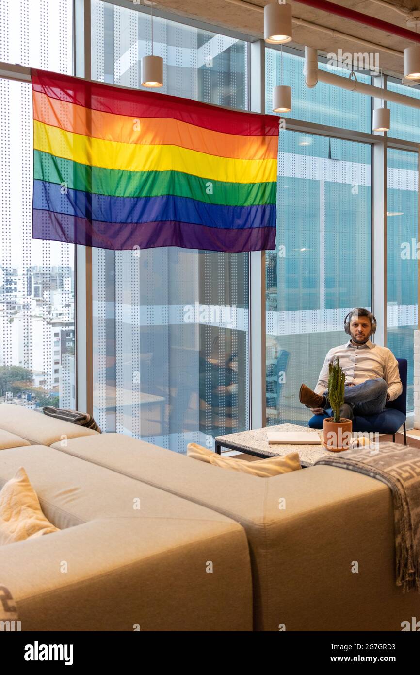 Handsome man in casual dress, contemplating the flag representing the LGBT community Stock Photo