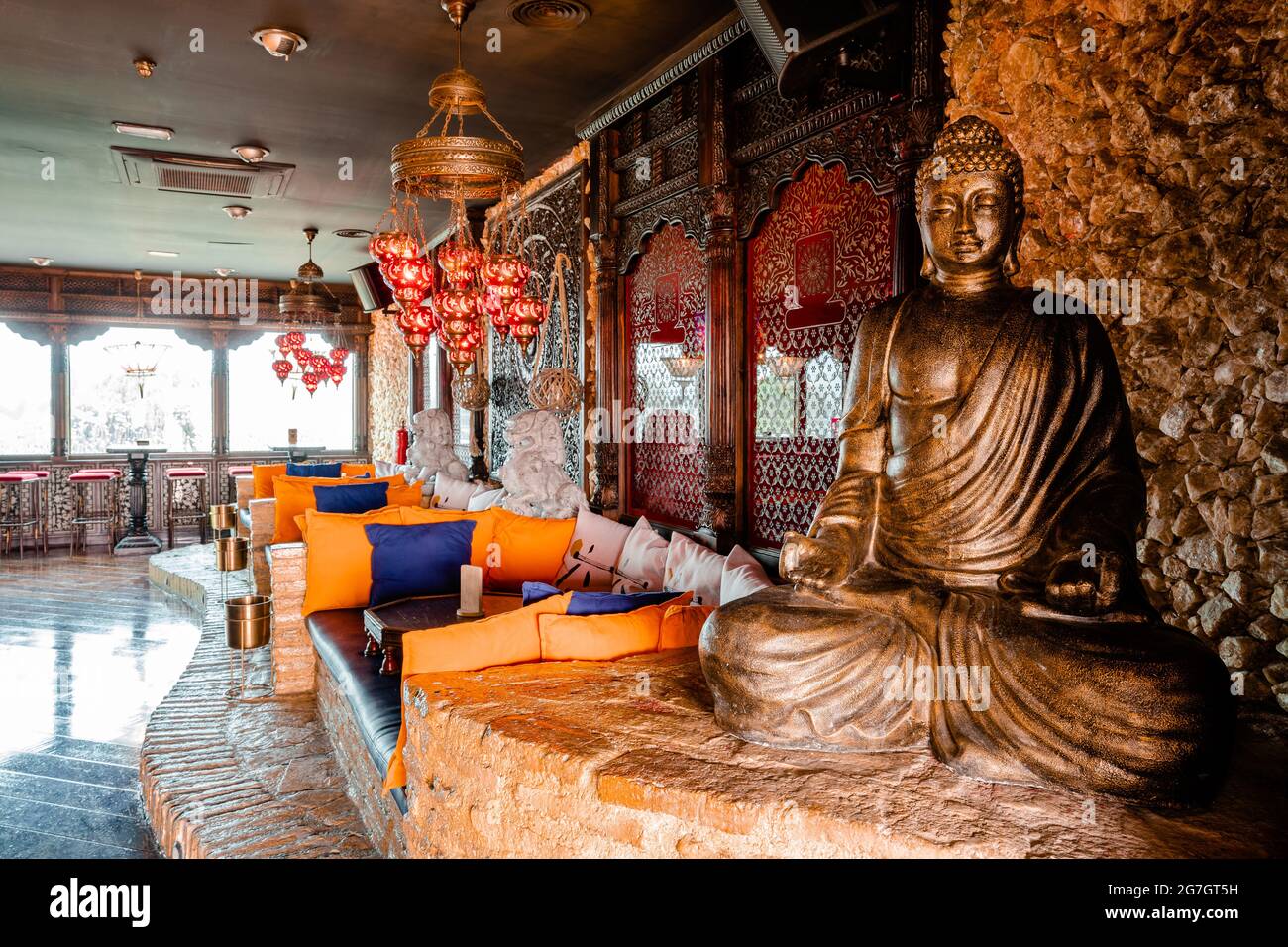Interior of cocktail bar with Buddha statue and cozy couches designed ...