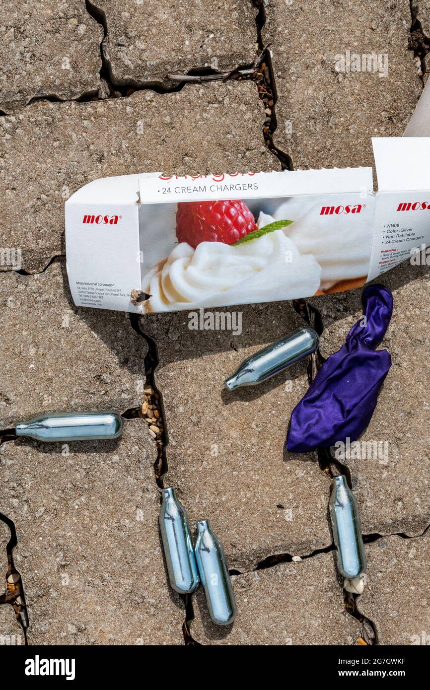 Cream chargers which contained nitrous oxide (laughing gas) and a used  balloon are indications of illegal drug use in this car park. Cambridge, UK  Stock Photo - Alamy