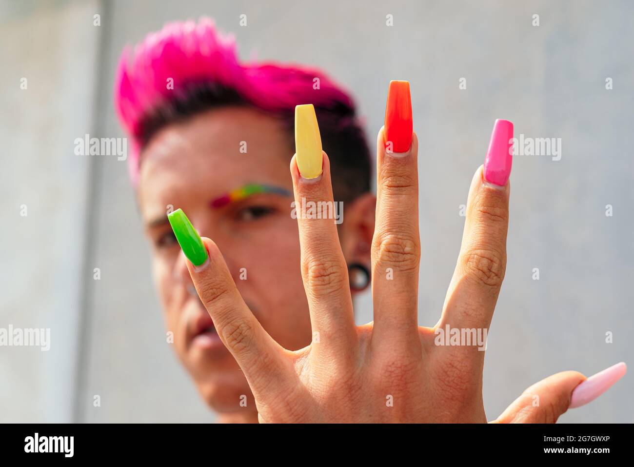 Confident gay male with long colorful nails looking at camera in street on  sunny day Stock Photo - Alamy