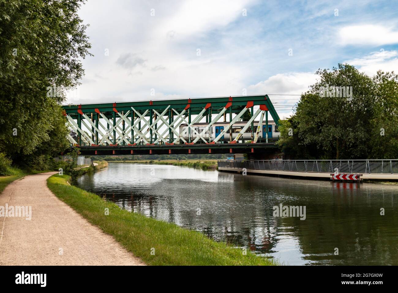 A train crosses the iron railway bridge over the River Cam at Stourbridge Common. Cambridge, UK. Stock Photo