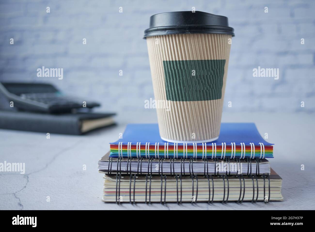 take away paper cup on stack of notepad on table  Stock Photo