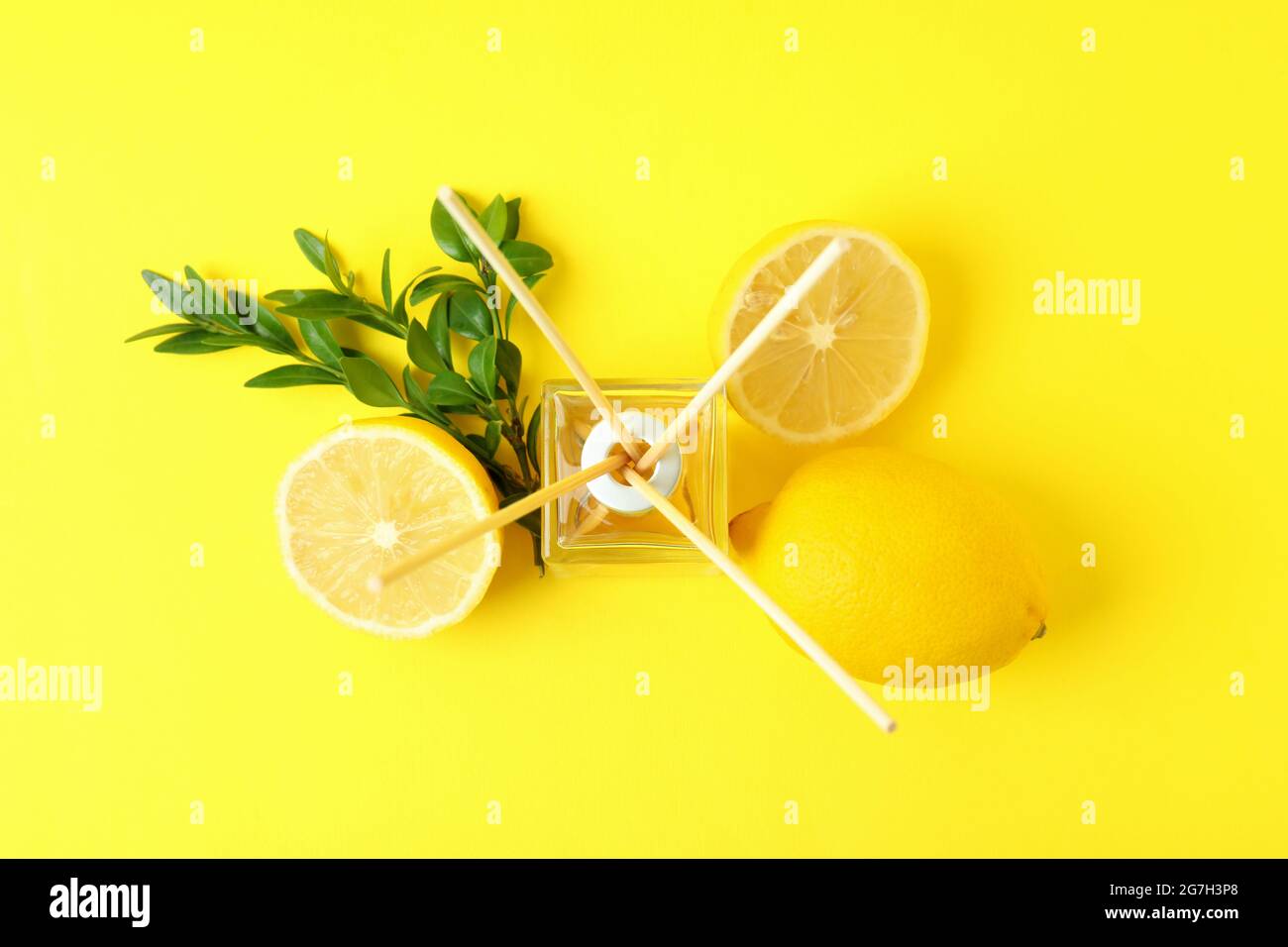 Diffuser, lemons and leaves on yellow background Stock Photo