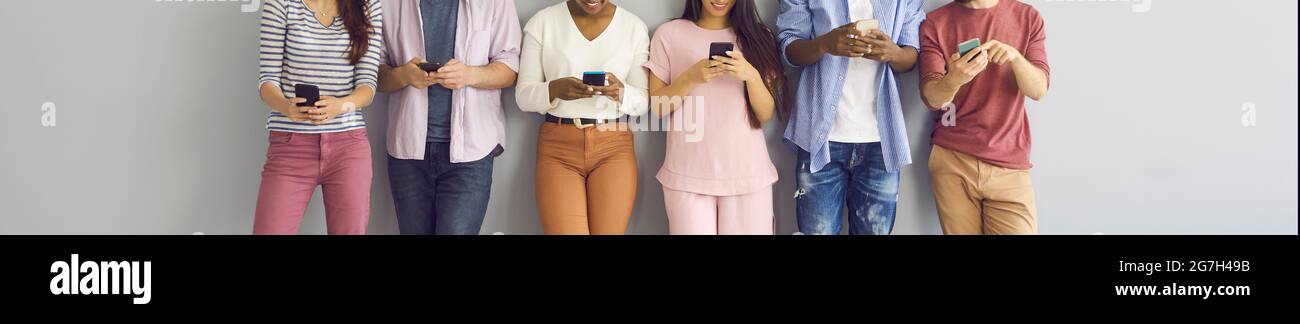 Diverse group of happy young people using mobile phones for online ...
