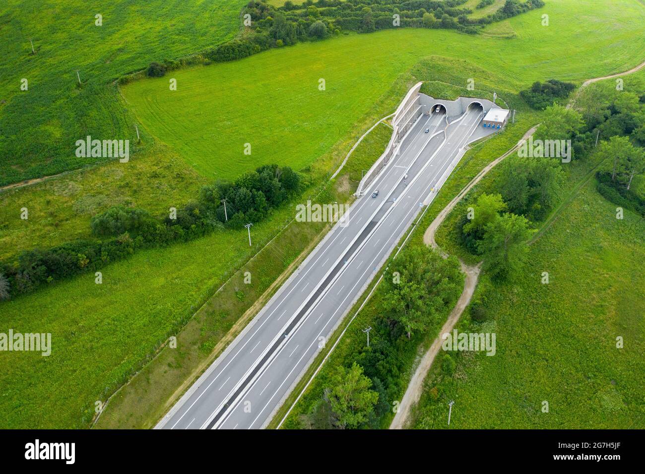 Top view on the tunnel entrance of highway covered with green grass