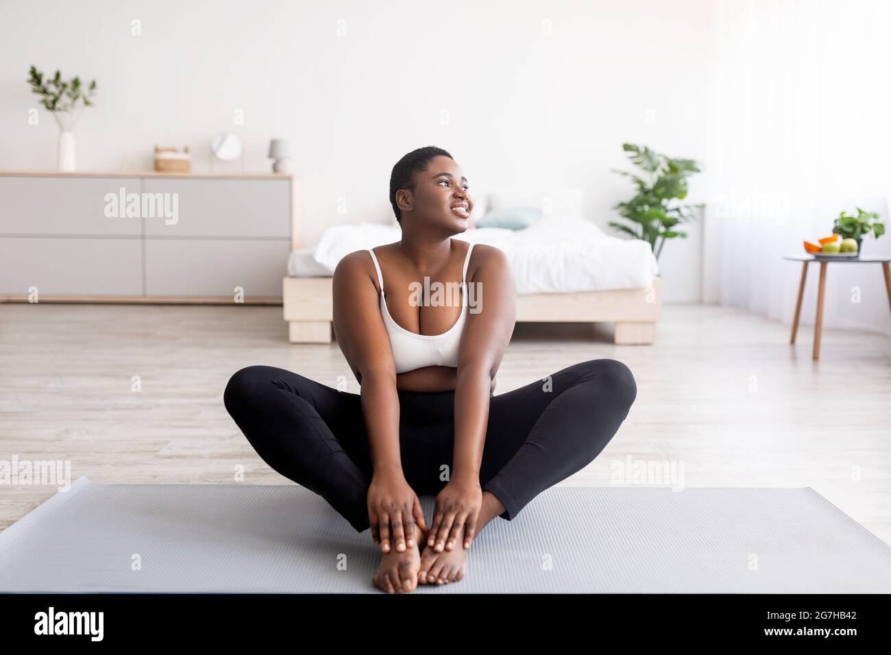 Full length of curvy black woman doing yoga butterfly pose on mat at home,  copy space. Overweight African American lady working out indoors,losing wei  Stock Photo - Alamy