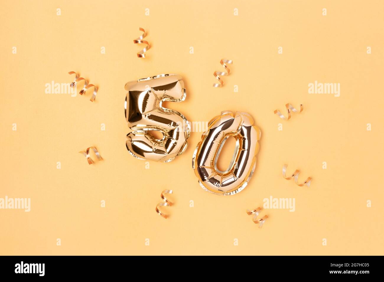 Number 50 golden inflatable balloons with confetti. Monochrome festive concept. Stock Photo