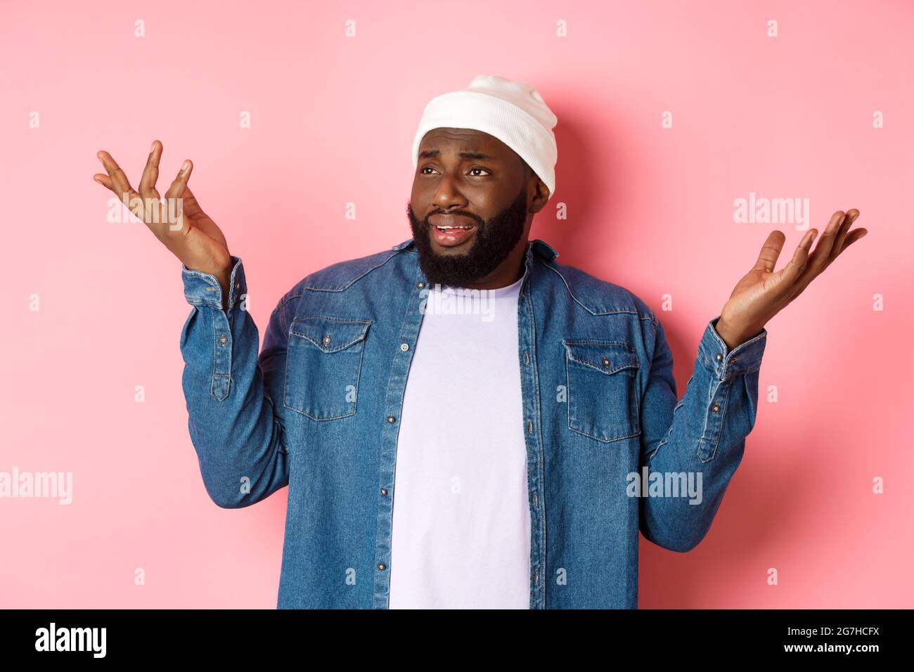 Skeptical confused man looking at something riddiculous, staring left and  shrugging, raising hands up puzzled, standing over pink background Stock  Photo - Alamy