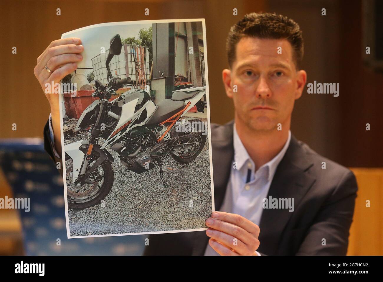 Duesseldorf, Germany. 14th July, 2021. Investigator Raimund Dockter shows a photo of one of the stolen motorcycles. Police presented the results of an international raid against classic car thieves. The gang is said to have stolen old Mercedes and Porsche cars as well as motorcycles worth almost four million euros. Credit: David Young/dpa/Alamy Live News Stock Photo