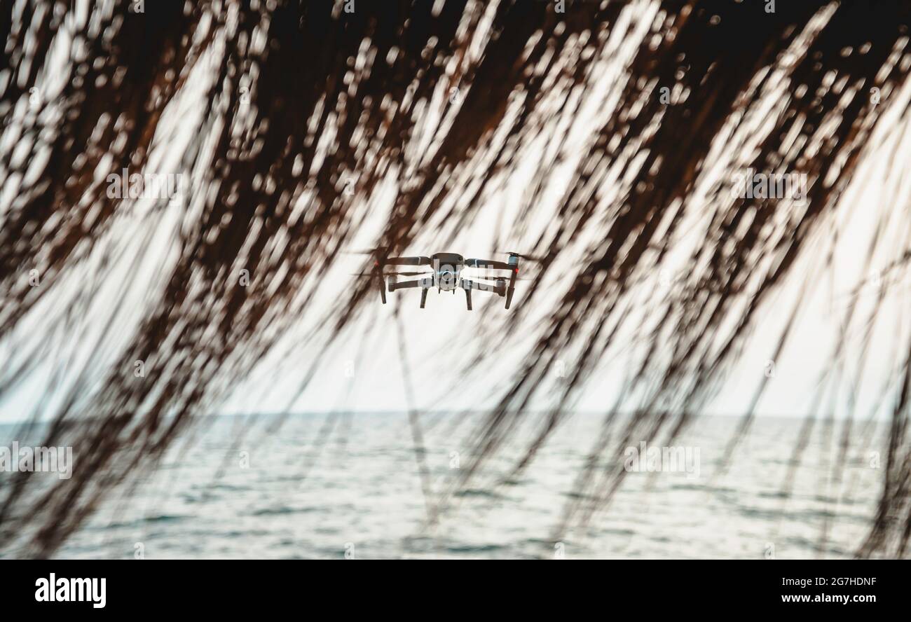 Drone with high resolution digital camera flying aerial over spectacular sunset sky on the beach - Drone flying over the beach for the safety of peopl Stock Photo