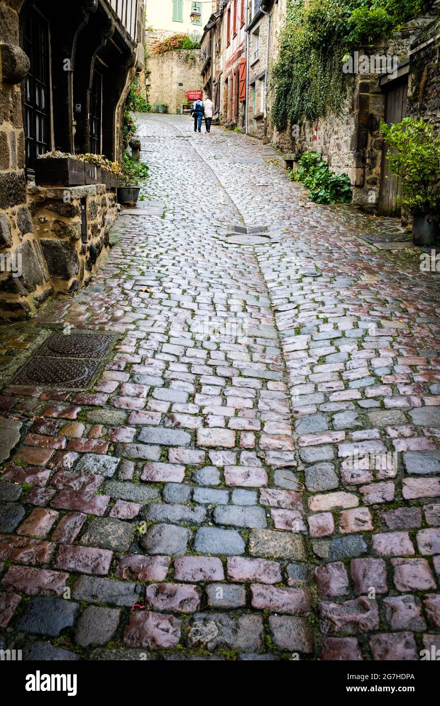 Couple walks on a cobblestone street in Dinan, Brittany, France. Stock Photo