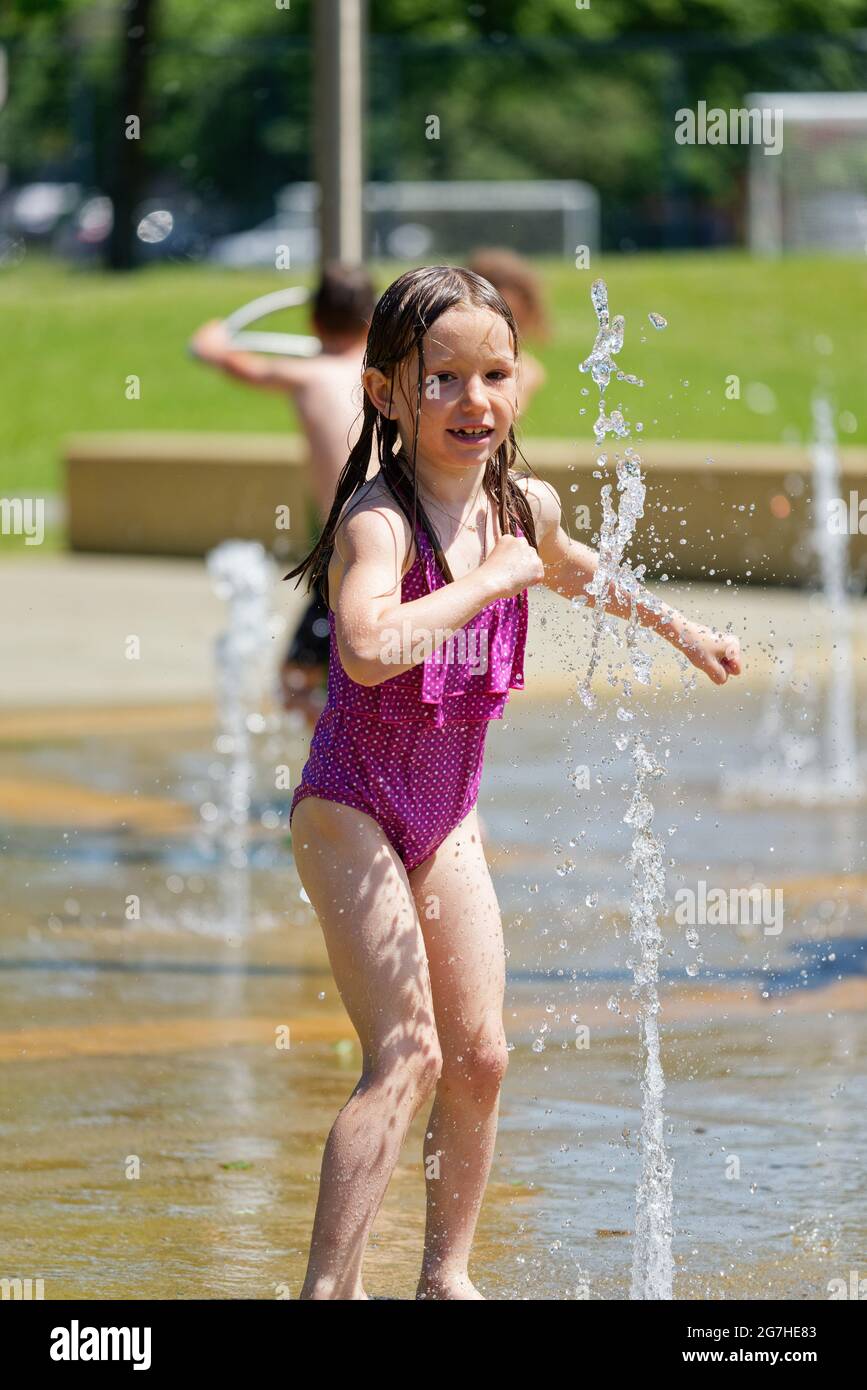 A little girl (7 yr old) playing in water games and fountains in Quebec City, Canada Stock Photo