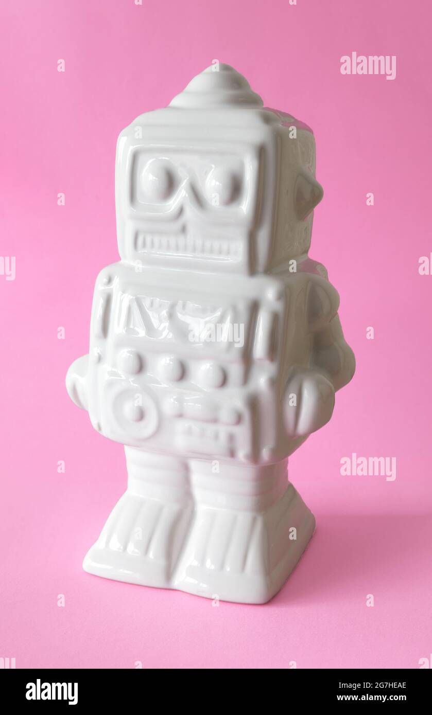 White robot figure on pink background Stock Photo