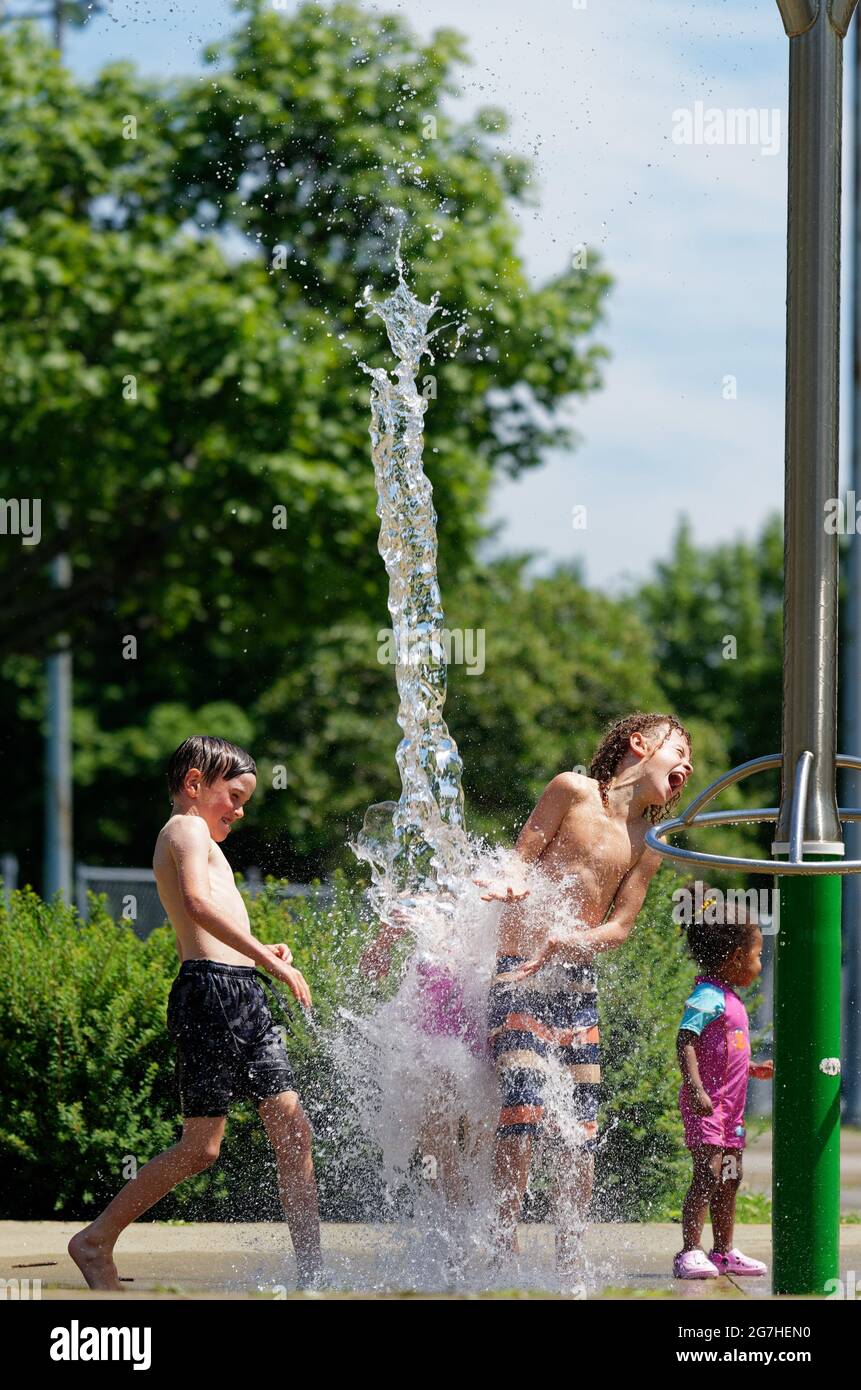 Three children playing in water games and fountains in Quebec City, Canada Stock Photo