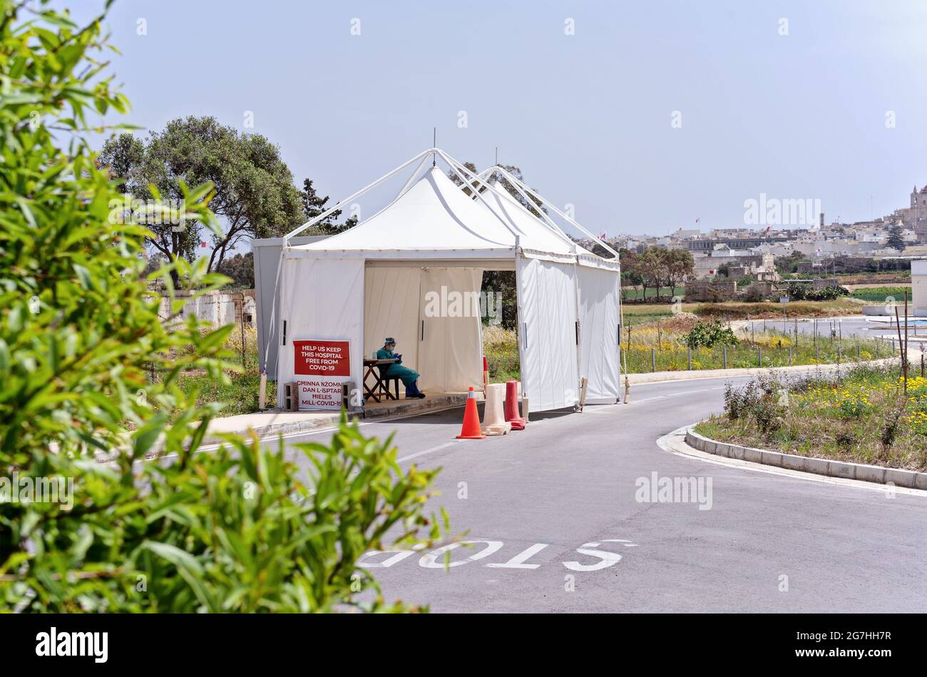Nurse sits in temporary pavilion for control coronavirus at entrance to