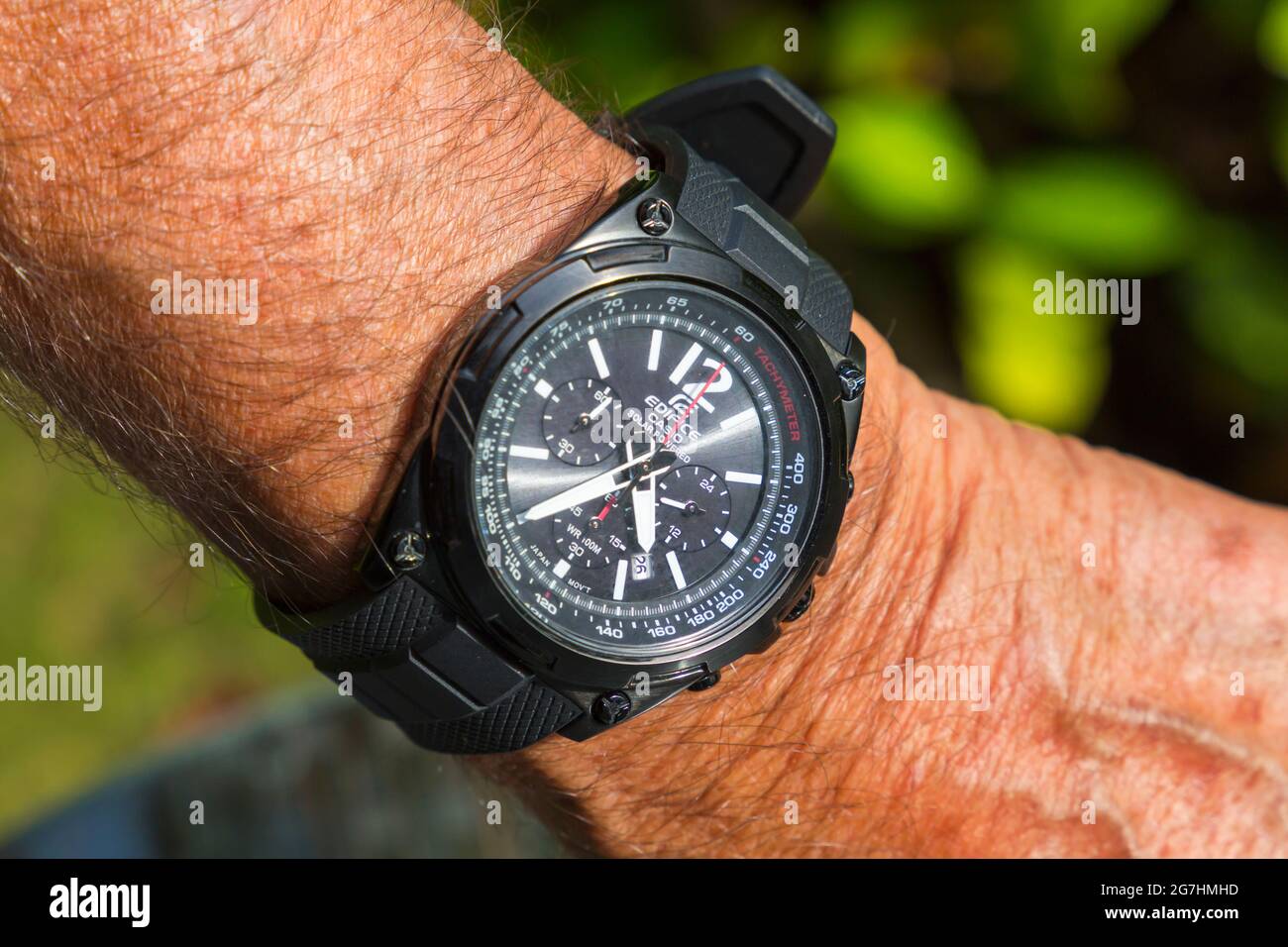 Man wearing Ediface Casio Solar Powered Tachymeter solar powered watch on wrist close up Stock Photo