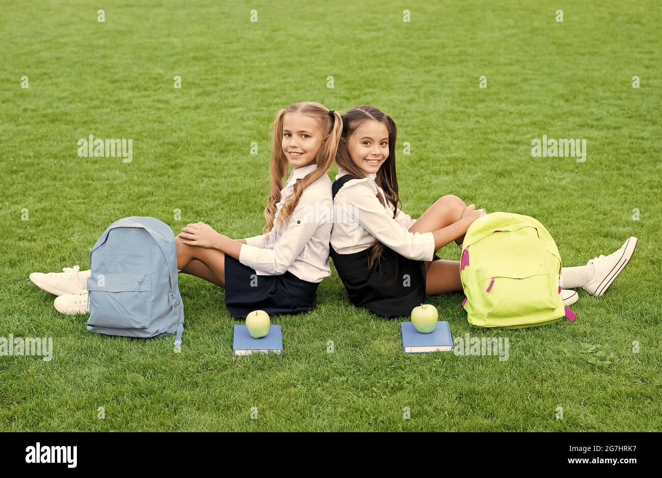 Friends makes you happy. School friends relax on green grass. Happy friends back to school. Classmate friends. School and education. Happy friendship Stock Photo