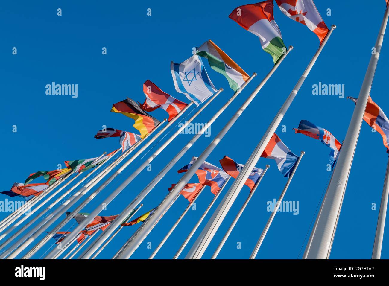 Different flags fluttering on flagpoles Stock Photo - Alamy