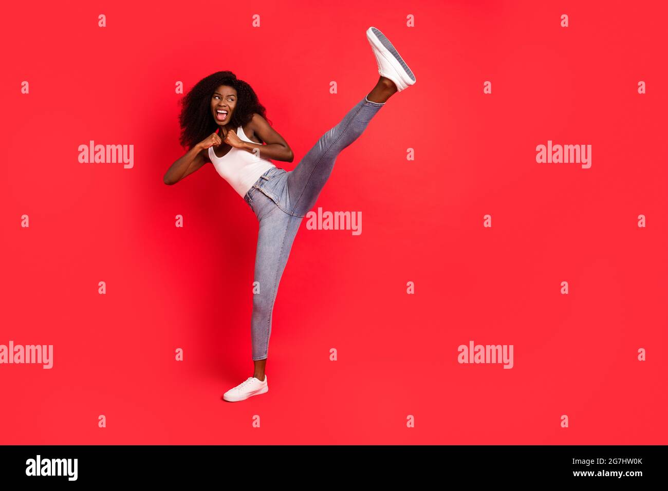 Full length photo of young attractive black girl fight battle kick leg