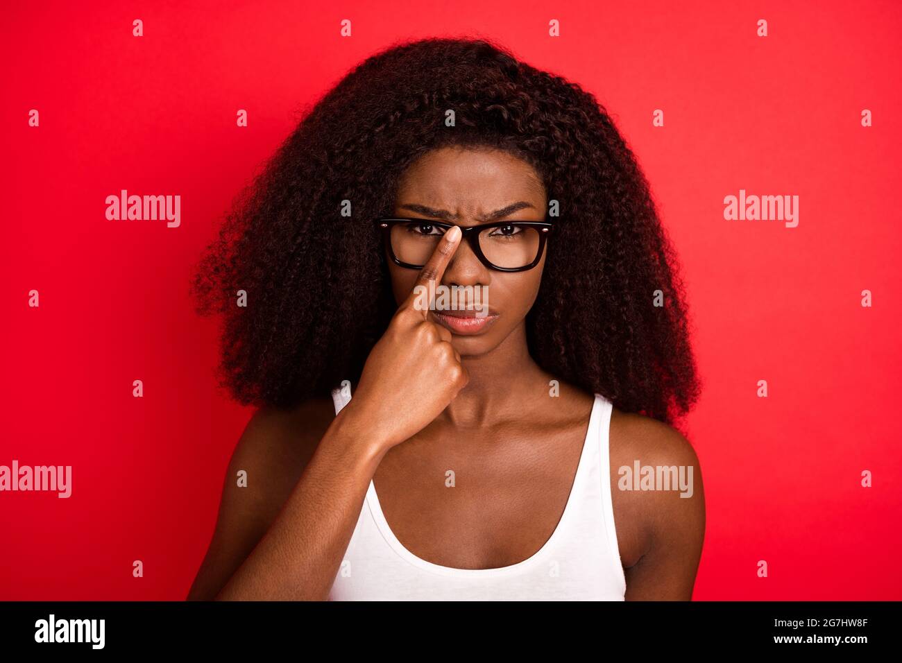 Photo of young attractive afro girl unhappy upset moody fix eyeglasses  isolated over red color background Stock Photo - Alamy
