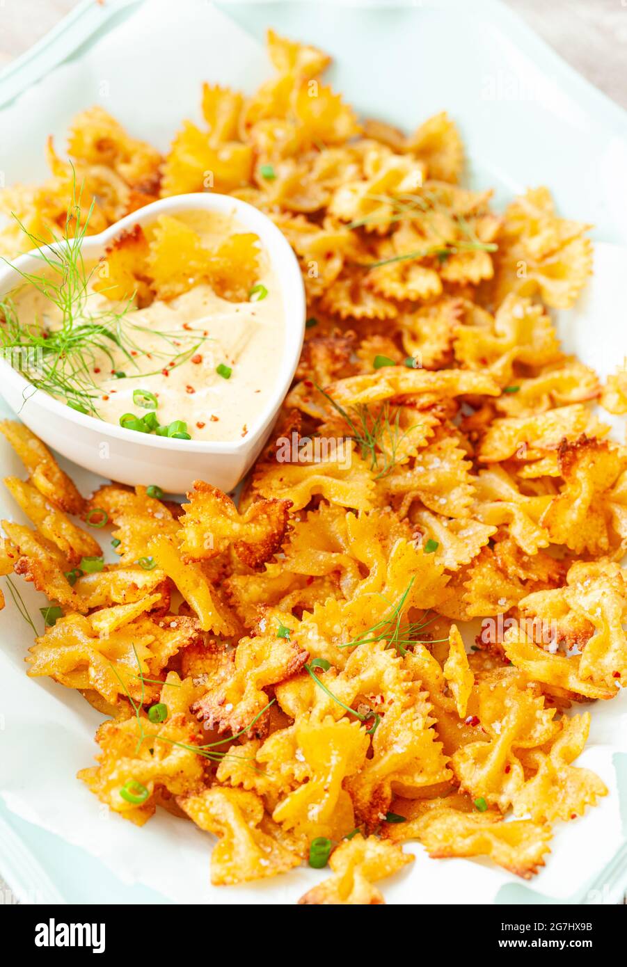 Spicy farfalle pasta chips with homemade herb dip Stock Photo Alamy
