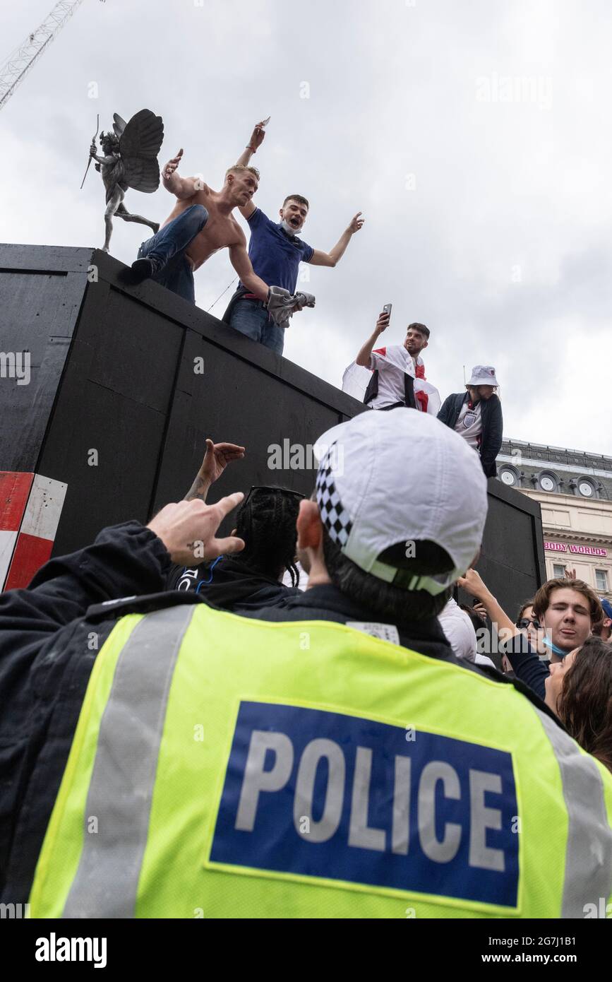 A police officer tries to control crowd before the England vs Italy Euro 2020 final, Piccadilly Circus, London, 11 July 2021 Stock Photo