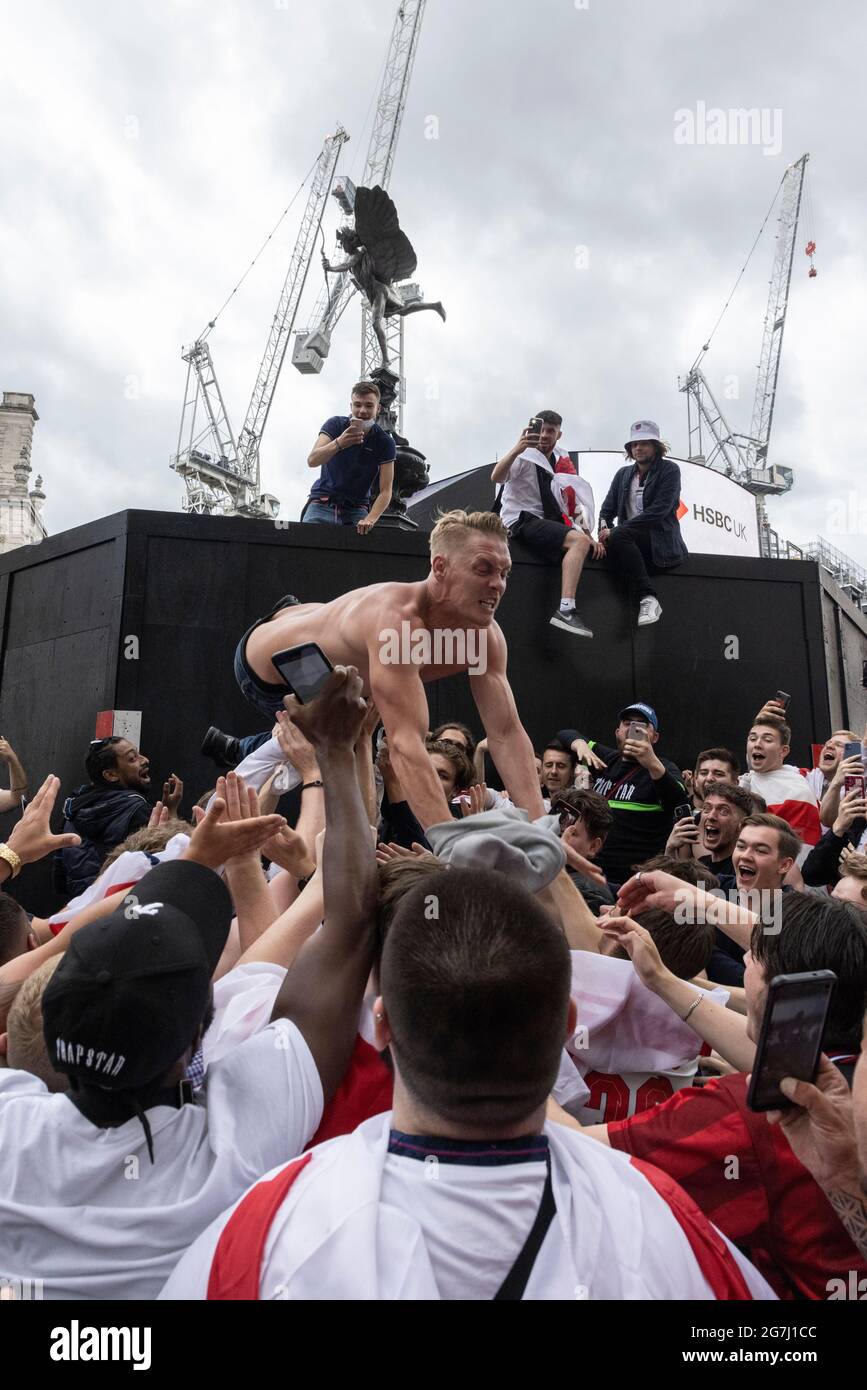 An English football fan leaps into crowd before the England vs Italy Euro 2020 final, Piccadilly Circus, London, 11 July 2021 Stock Photo