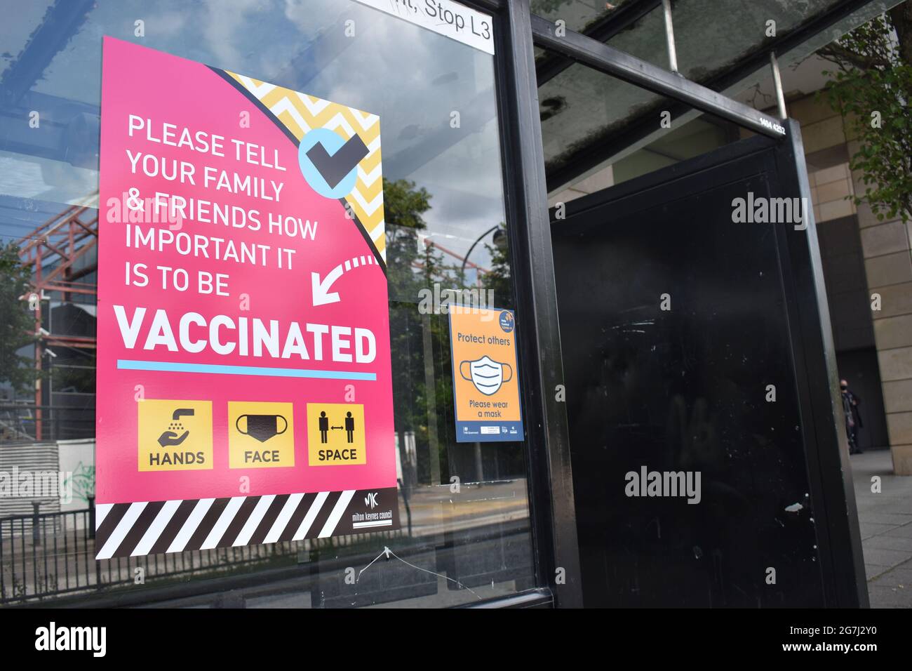 Notice at a bus stop: 'Please tell your family and friends how important it is to be vaccinated'. Stock Photo