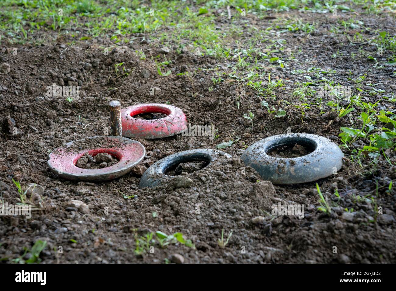 Quoits in the wet soil around the peg Stock Photo Alamy
