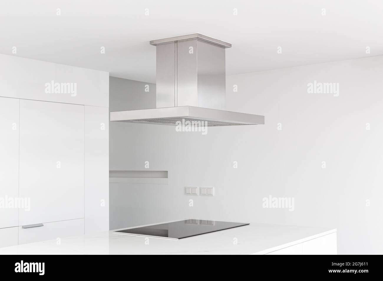 Cooker hood and electric stove of a modern and minimalist kitchen Stock Photo