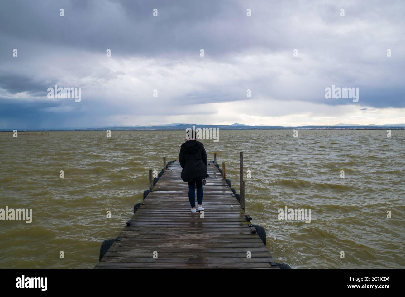 Girl walking along wooden jetty hi-res stock photography and images - Alamy
