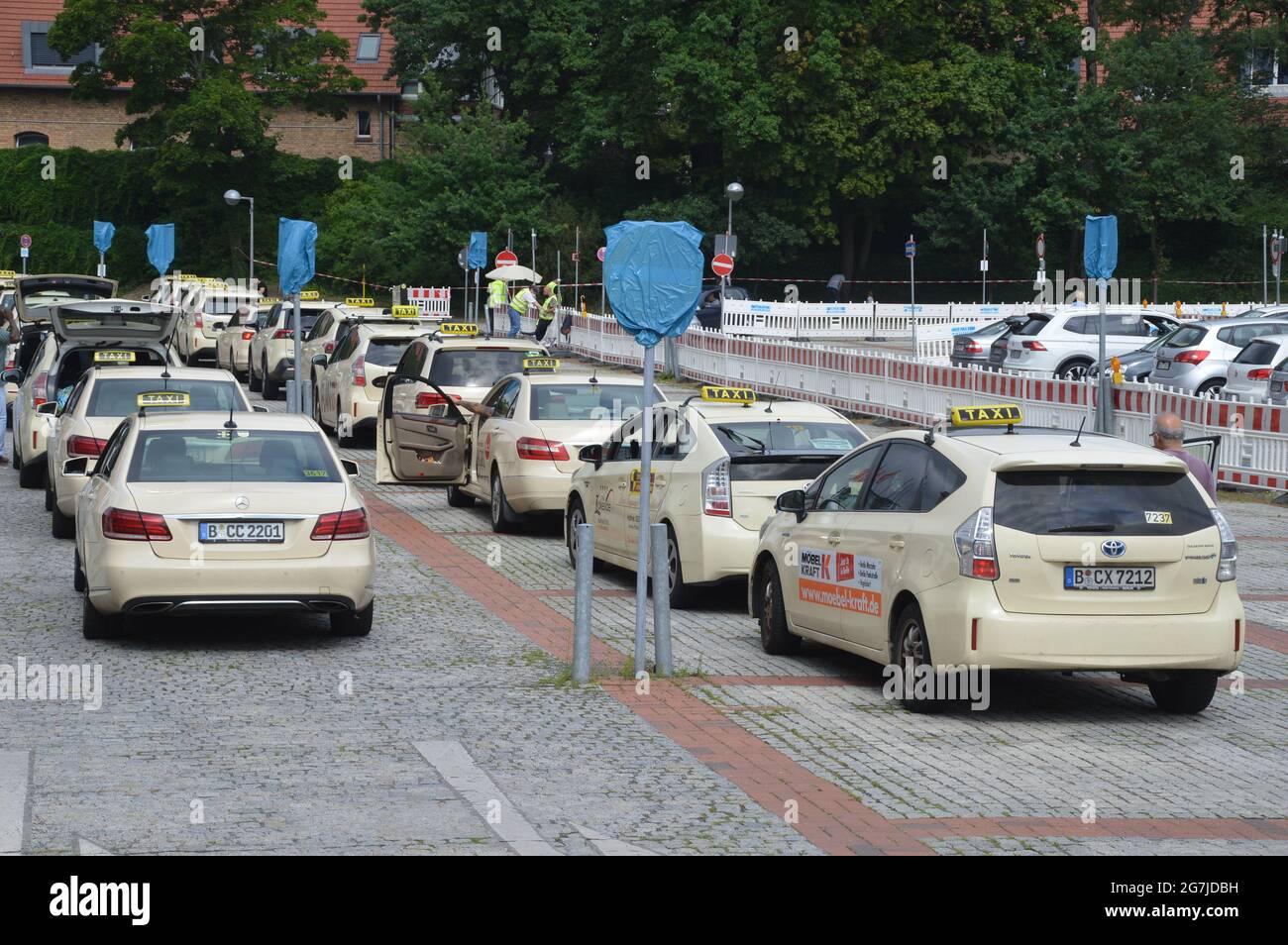 Taxis parked waiting to pick passengers outside the vaccination centre of the Berlin fairgrounds - Berlin, Germany - July 14, 2021. Stock Photo