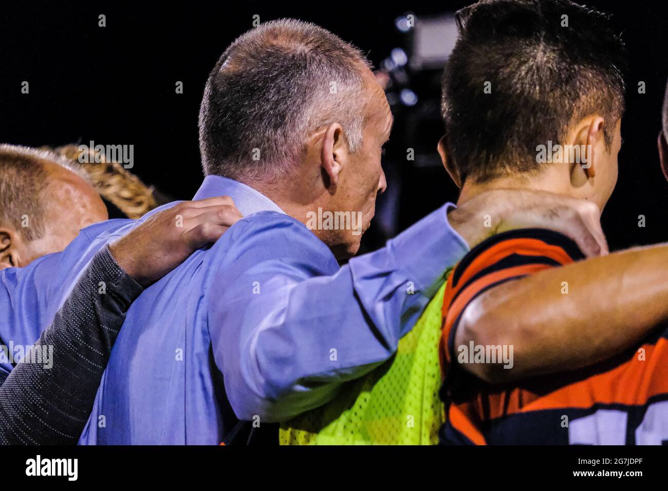 Football coach and players in a huddle Stock Photo